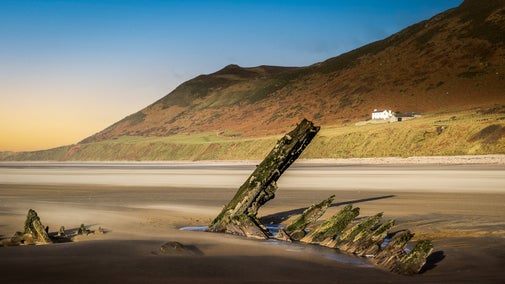 The remains of the ship Helvetia on the beach with Rhossili Old Rectory in the background, South Wales